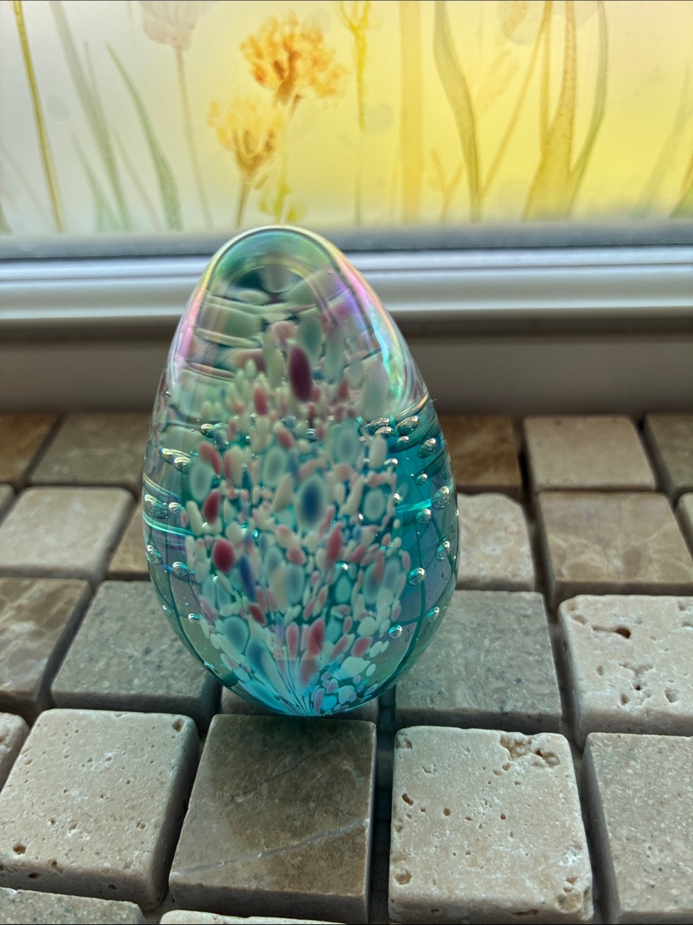 A Glass Eye Studio iridescent controlled bubble glass egg paperweight.